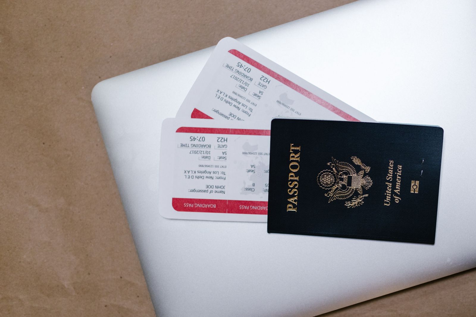 Pasaporte y documentos de viaje organizados sobre una computadora